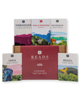 Reads Coffee Roasters coffee tasting box set featuring a large burgundy box in the center with five single-origin coffee pouches displayed behind it and two smaller pouches in front, all on a white background.