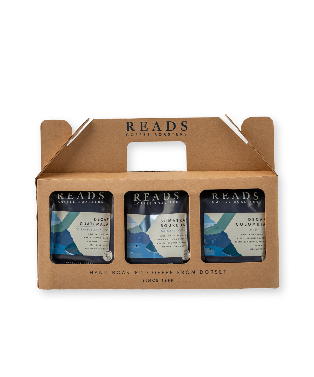 A 3-pack of Reads Coffee Roasters hand-roasted coffee in a brown cardboard carrier tray. The three cans feature blue and white labels with mountain graphics.