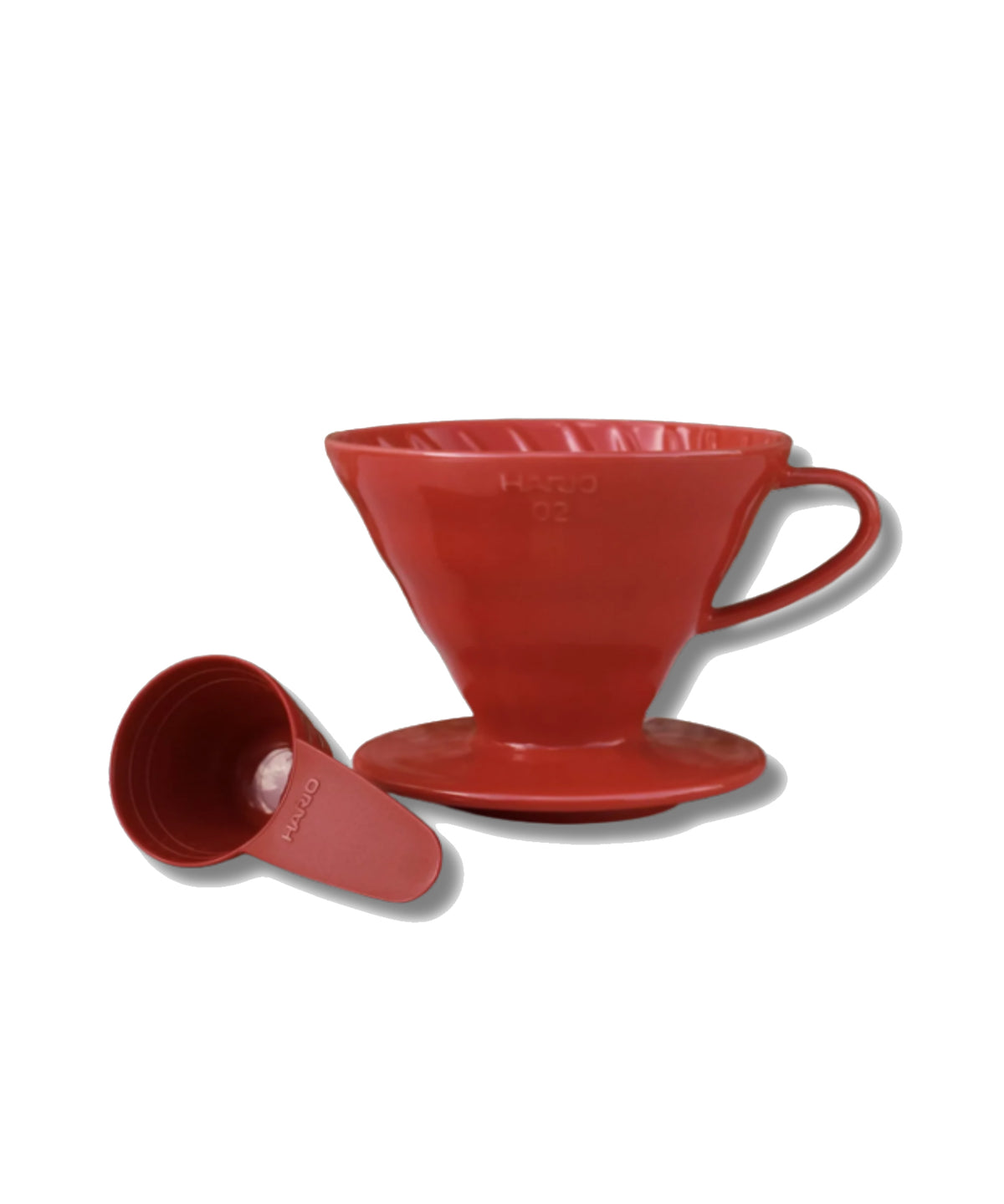 A red V60 pour-over coffee dripper with its matching saucer and funnel placed beside it on a clean white background.