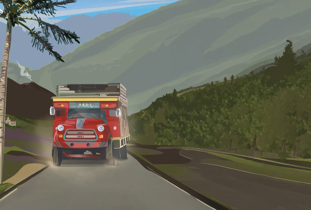 Red truck on a road with mountains and trees in the background