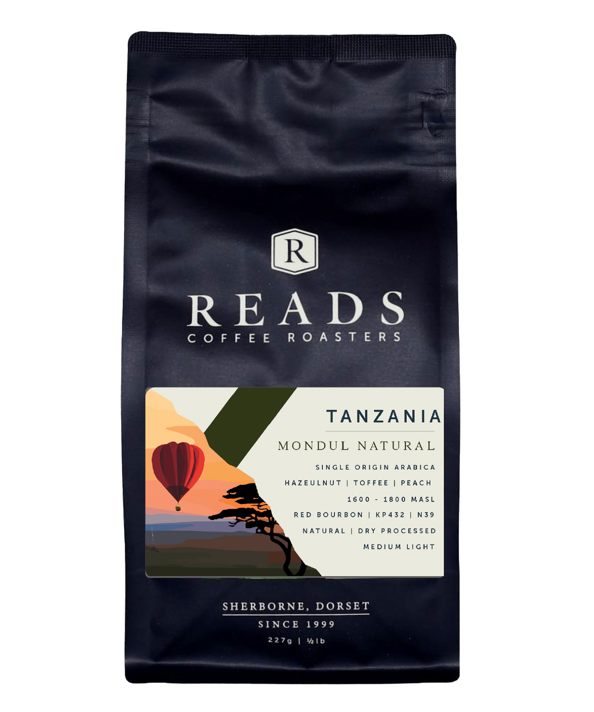 A bag of Reads Coffee Roasters Tanzania Mondul Natural coffee, featuring a dark navy blue bag with white text and a colorful geometric label showing a hot air balloon and tree.